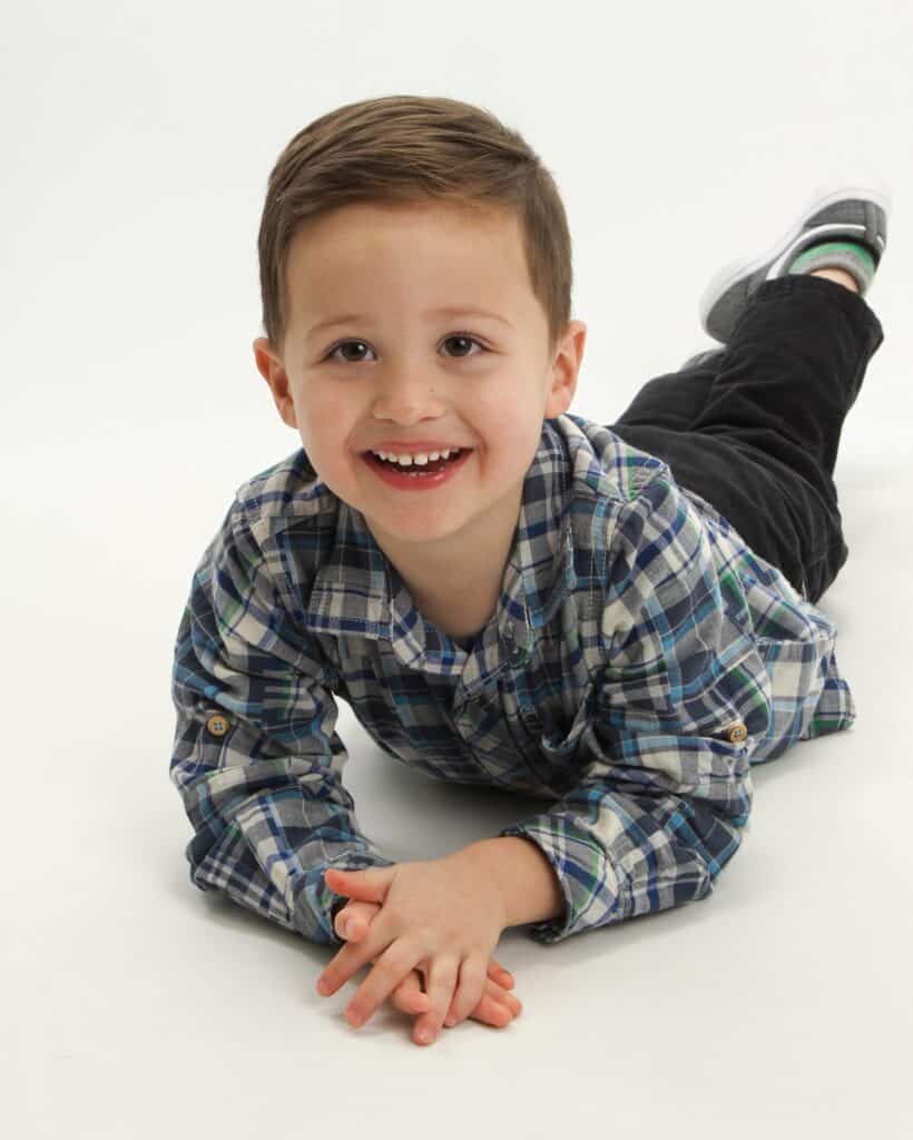 Young child smiling on floor