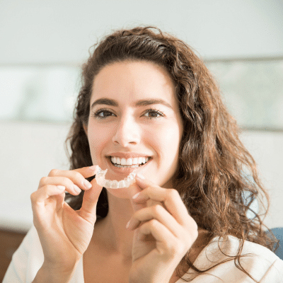 The role of orthodontic technology in modern orthodontics 2 Woman putting on clear aligners, representing orthodontic technology
