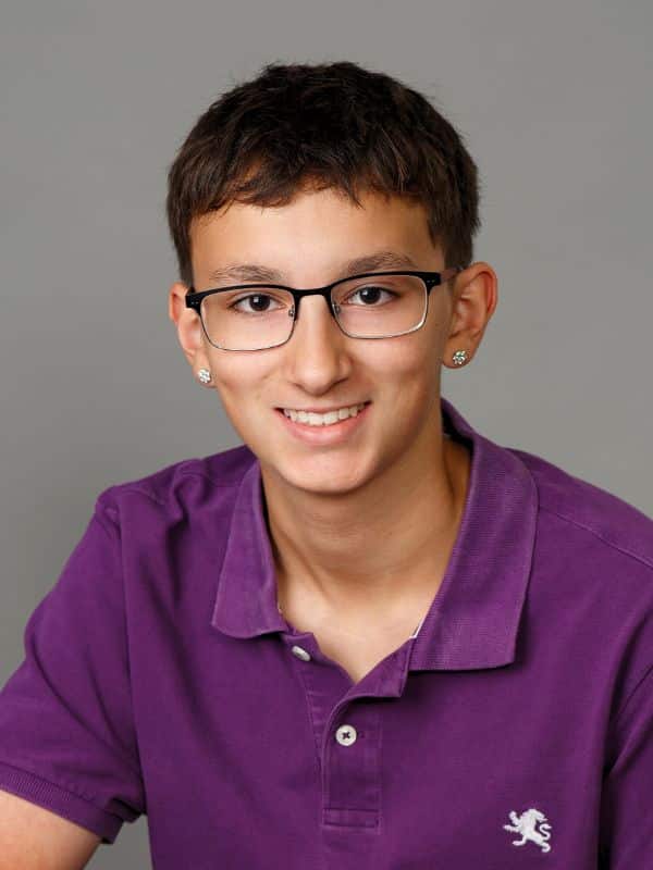 Confident smile after treatment Boy with glasses smiling in purple shirt after smile transformation