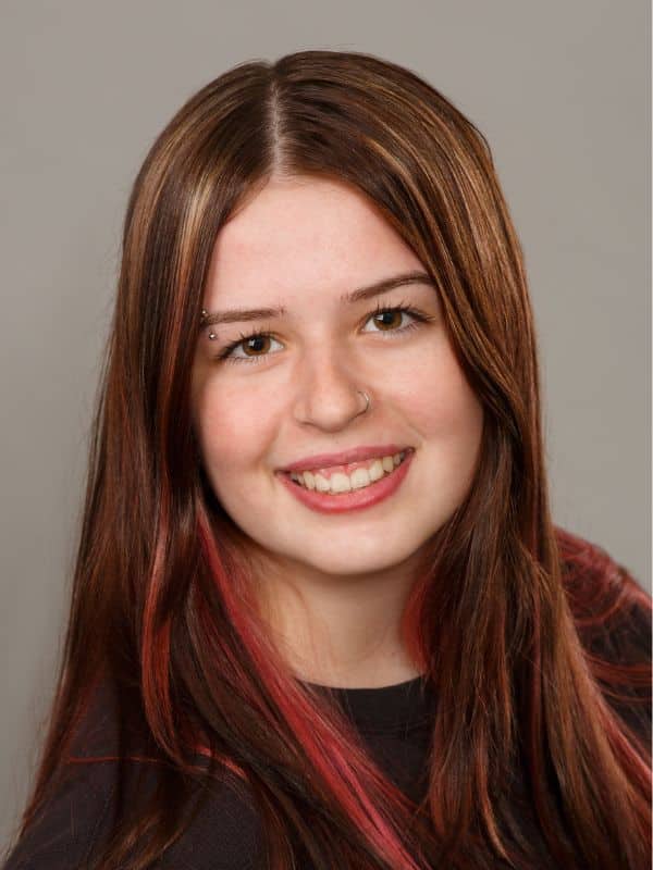 Jones-family-orthodontics-ella Young girl smiling with black shirt and pink highlights at jones family orthodontics
