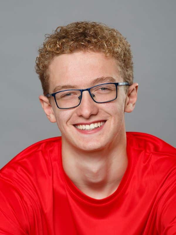 Jones-family-orthodontics-julian Young boy smiling with red shirt and glasses at jones family orthodontics