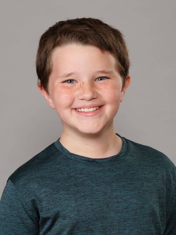 Jones-family-orthodontics-matthew Young boy smiling in blue shirt at jones family orthodontics