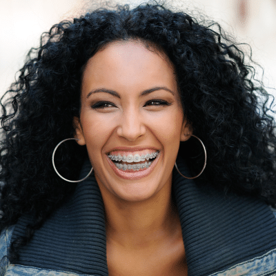 Top 10 things to expect when getting braces 2 Smiling woman with braces and earrings, representing what to expect during braces treatment